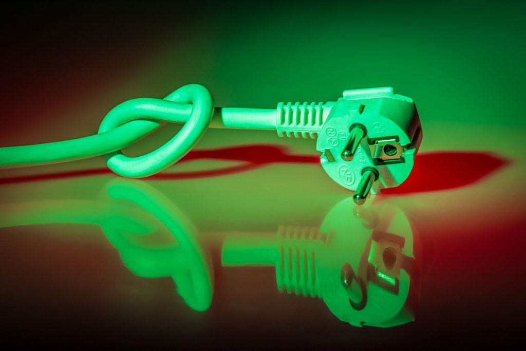 Kabel zasilający zawiązany w węzeł obok wtyczki, w zielonym świetle
