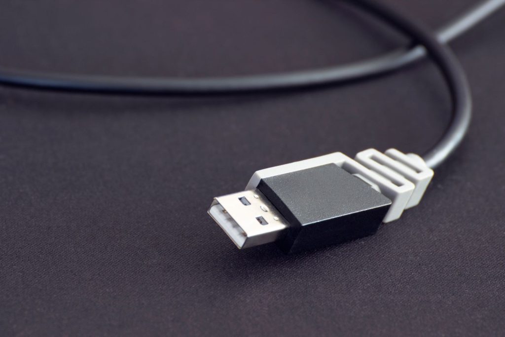 Kabel USB zwinięty na ciemnym blacie